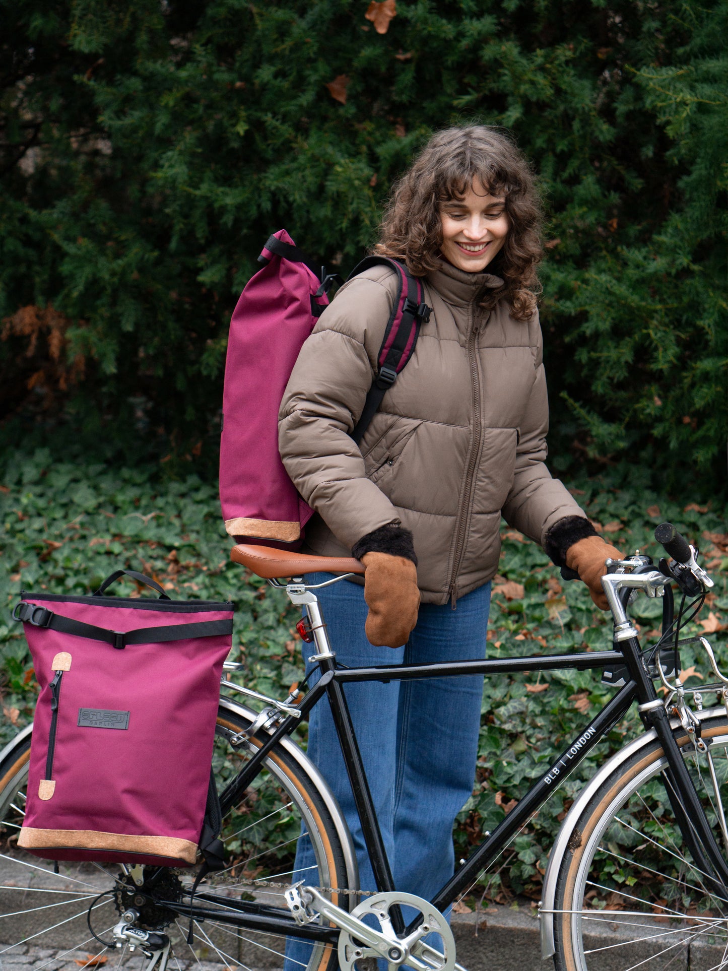 Liz Bordeaux als Rucksack von einer Frau getragen und als Fahrradtasche angehangen – bequeme gepolsterte Träger, nachhaltig, fair und ideal für den täglichen Einsatz auf Rücken und Rad
© Spleen Berlin