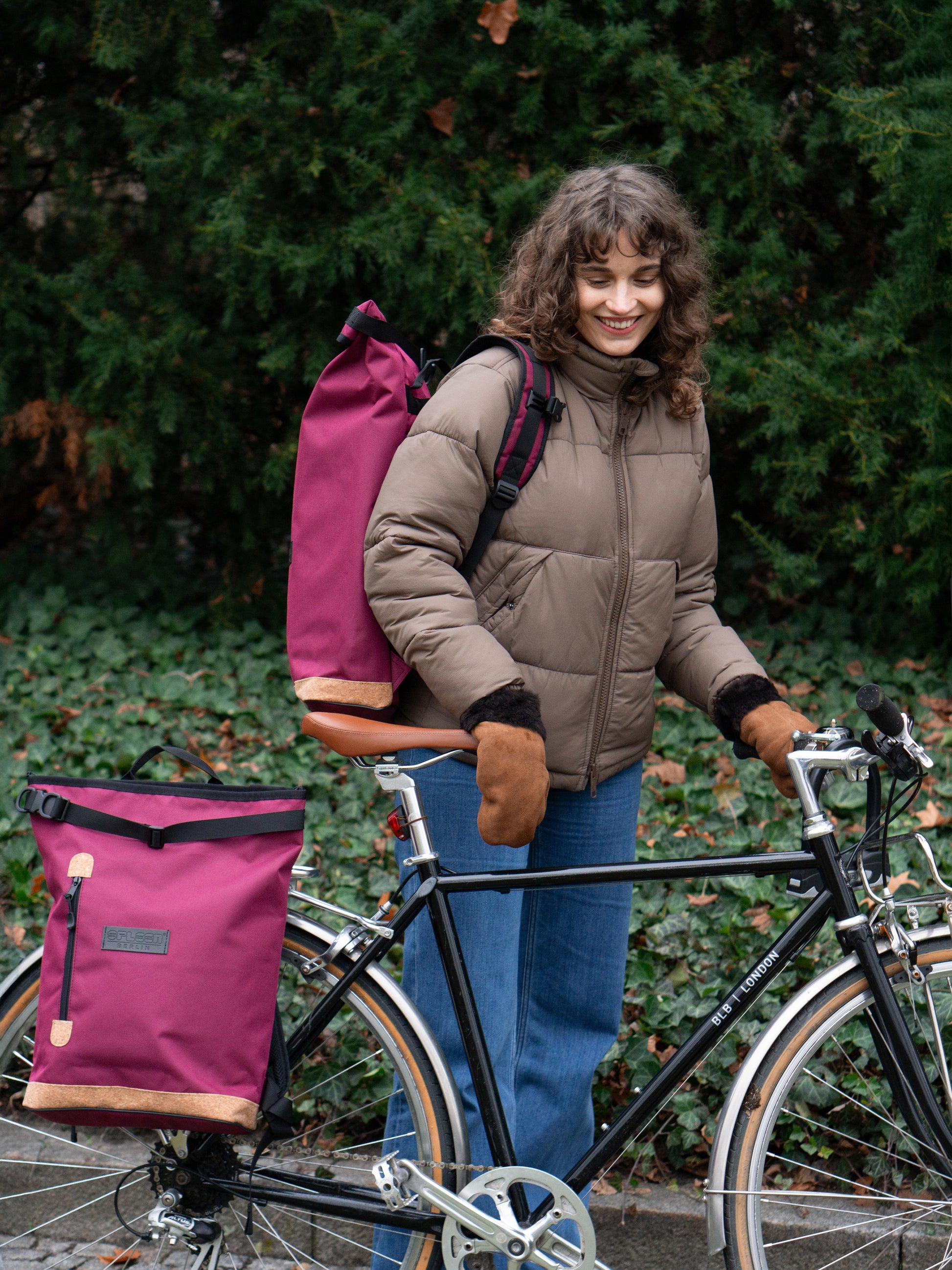 Liz Bordeaux als Rucksack von einer Frau getragen und als Fahrradtasche angehangen – bequeme gepolsterte Träger, nachhaltig, fair und ideal für den täglichen Einsatz auf Rücken und Rad
© Spleen Berlin