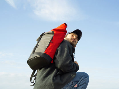 Person trägt reflektierenden Fahrradrucksack Bob Red Glow – urbanes, nachhaltiges Rolltop-Modell für mehr Sicherheit im Strassenverkehr von Spleen Berlin fair produziert in Europa. 
© Spleen Berlin
