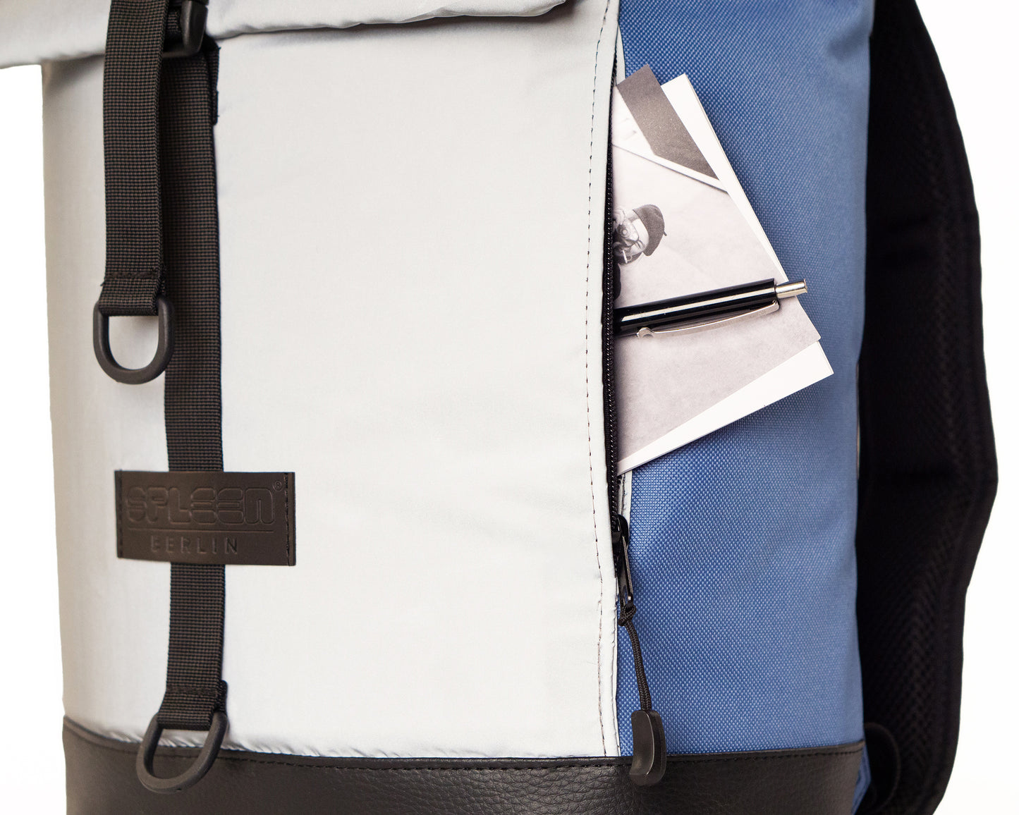 Fahrradrucksack Bob Ice Blue mit Rolltop –Detailansicht der reflektierenden Frontasche mit versteckter Reißverschlußtasche seitlich,  minimalistisches Design, vegan, wasserabweisend, von Spleen Berlin  hochwertig verarbeitet